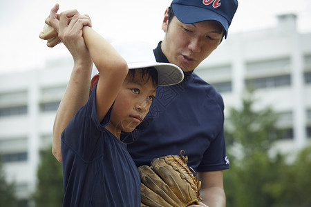 制服指示教练男孩棒球运动员实践的投球画象图片