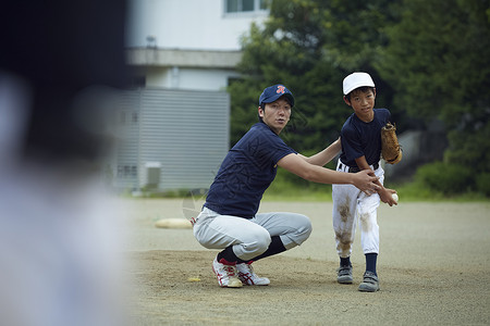 日本伸出坚持的男孩棒球运动员实践的投球画象图片