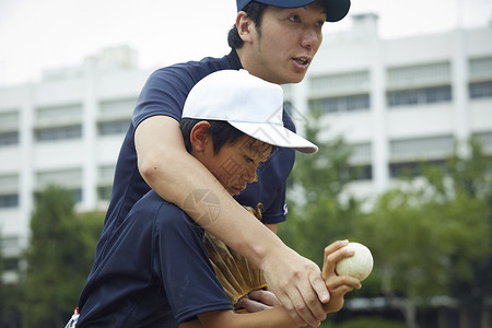 伸出教练小孩男孩棒球运动员实践的投球画象图片