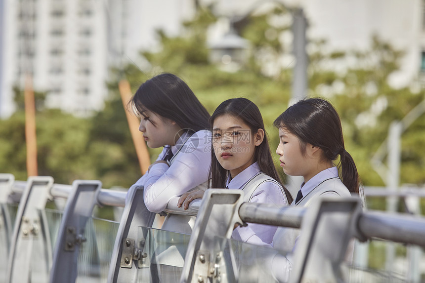 高中生在校园内趴在栏杆上聊天图片