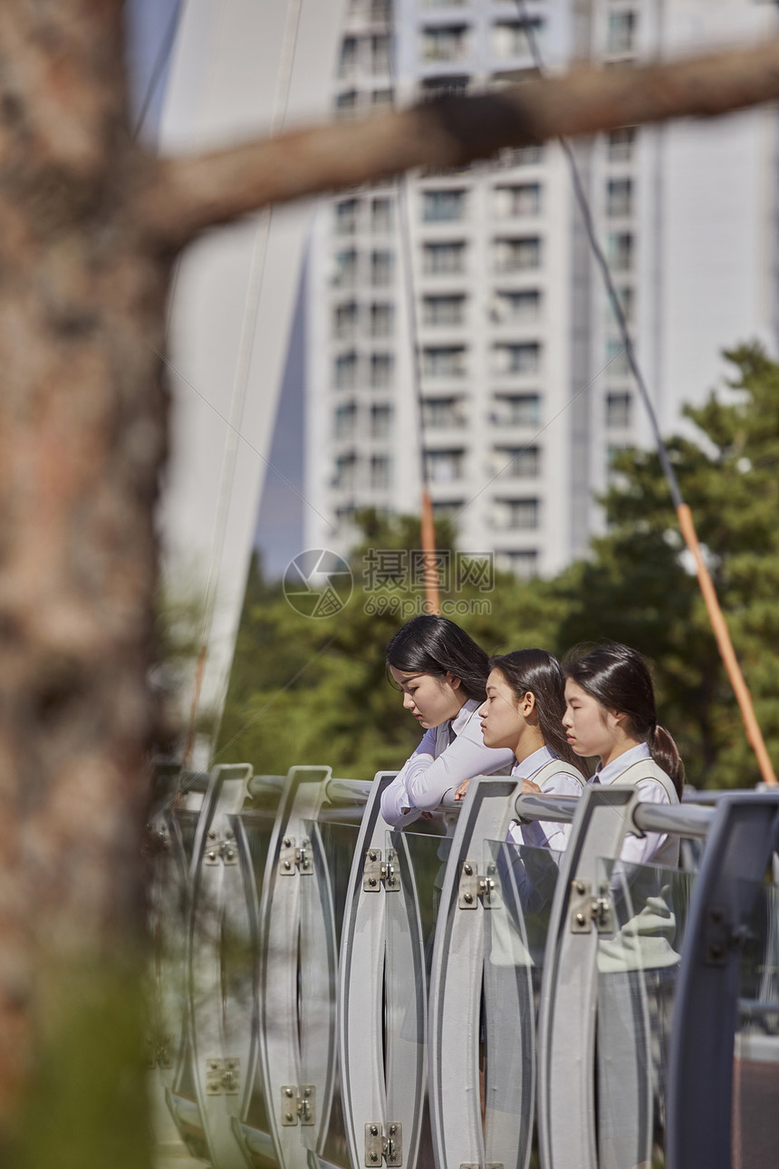 高中生在校园内趴在栏杆上聊天图片