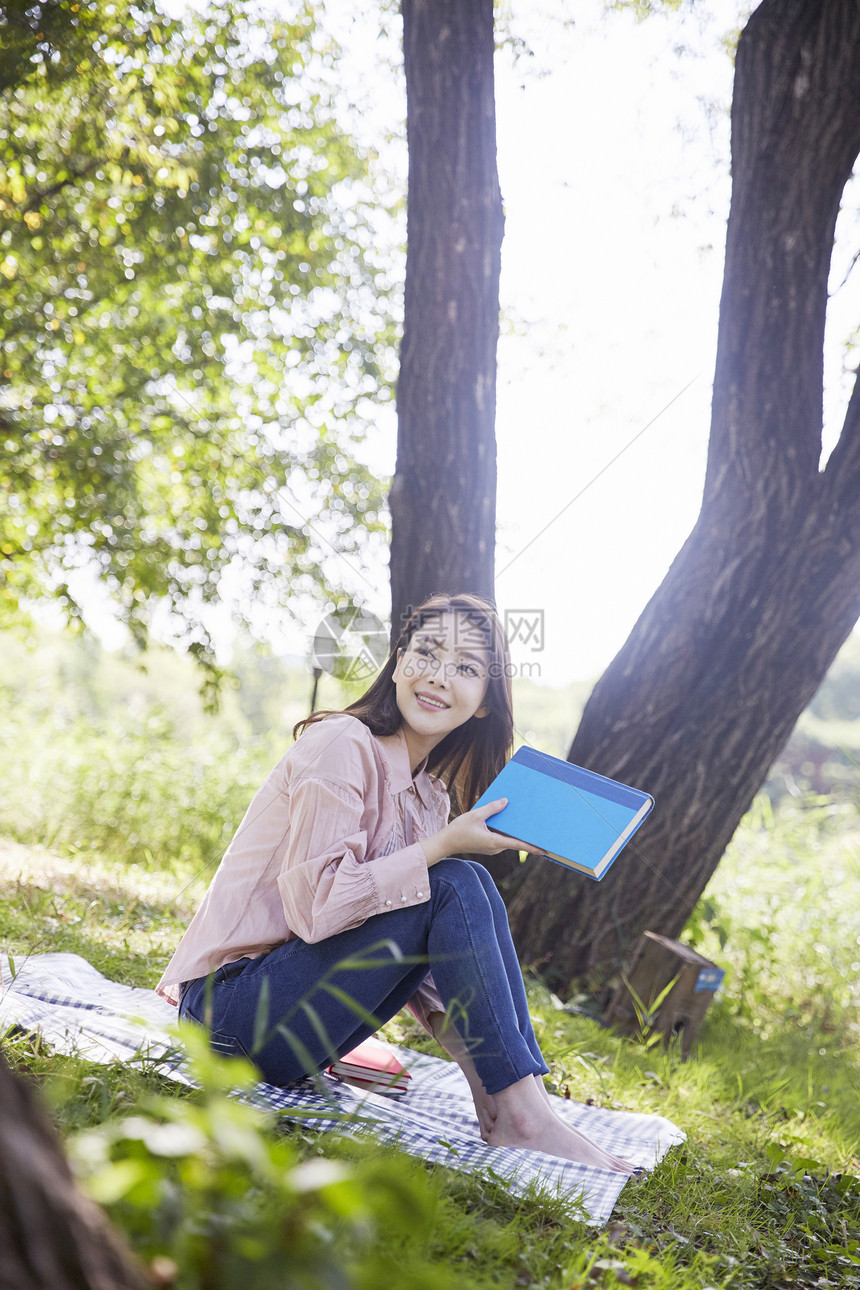 公园野餐阅读的年轻女性图片