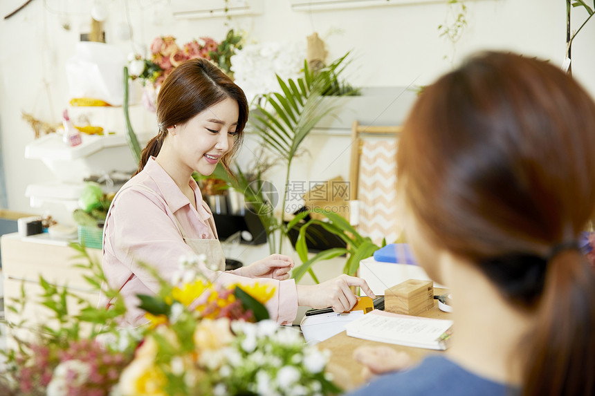 花店柜台刷卡的年轻店员图片