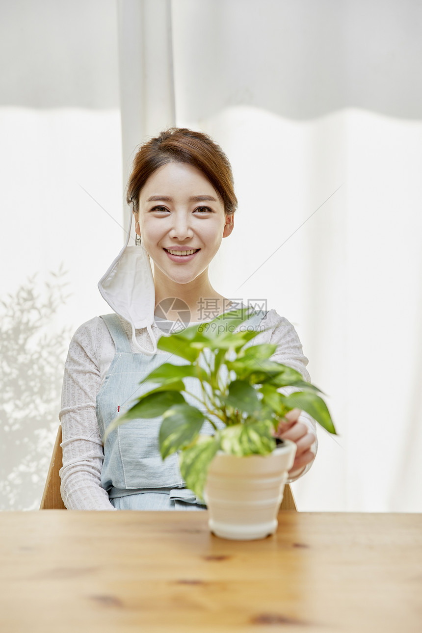 拿着盆栽微笑的年轻女性图片