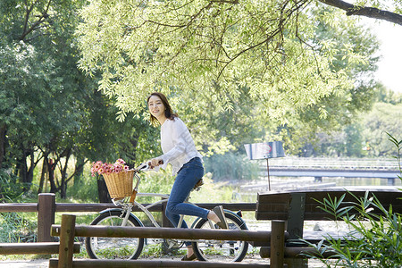 公园郊游骑着自行车的年轻女性图片