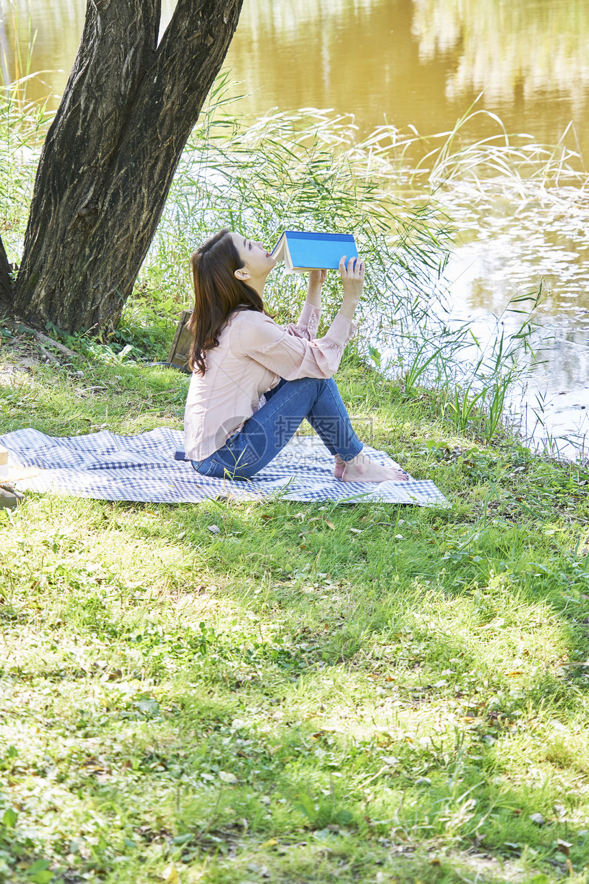 公园小河边阅读的青年女性图片