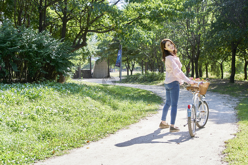 春日里推着自行车的年轻女子图片