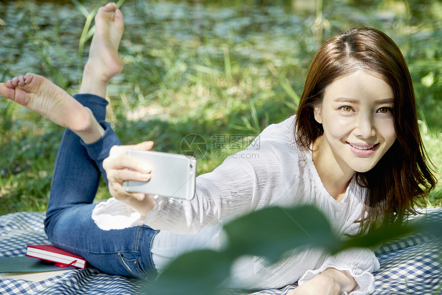 趴在野餐垫上自拍的女性图片