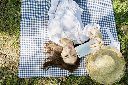 躺在野餐垫上微笑的女性图片