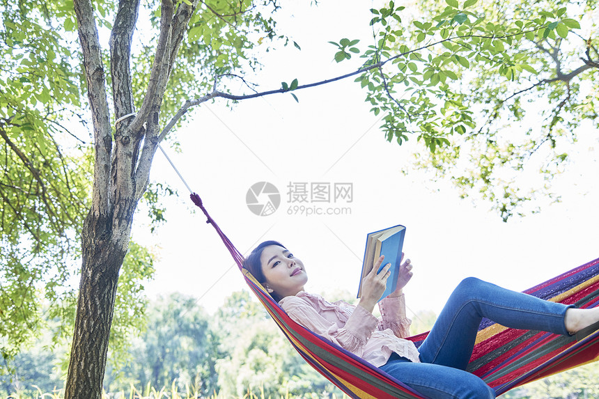 公园吊床上阅读的女性图片