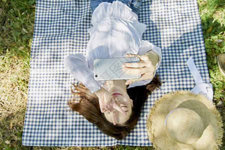躺在野餐垫上自拍的女性图片