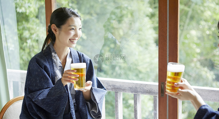 微笑日本夏天在旅馆的妇女饮用的啤酒图片