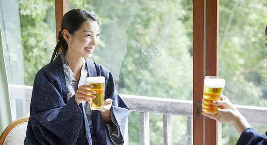 微笑日本夏天在旅馆的妇女饮用的啤酒图片