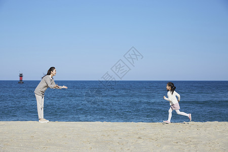 海边沙滩上小女孩跑向妈妈图片