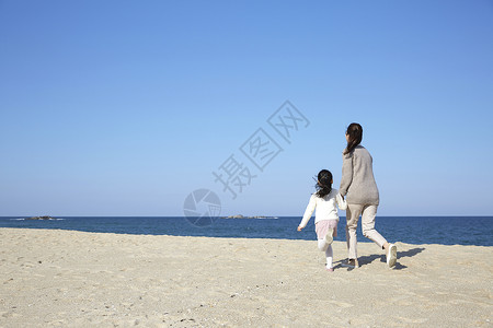 假期海边的母女旅行奔跑背影图片