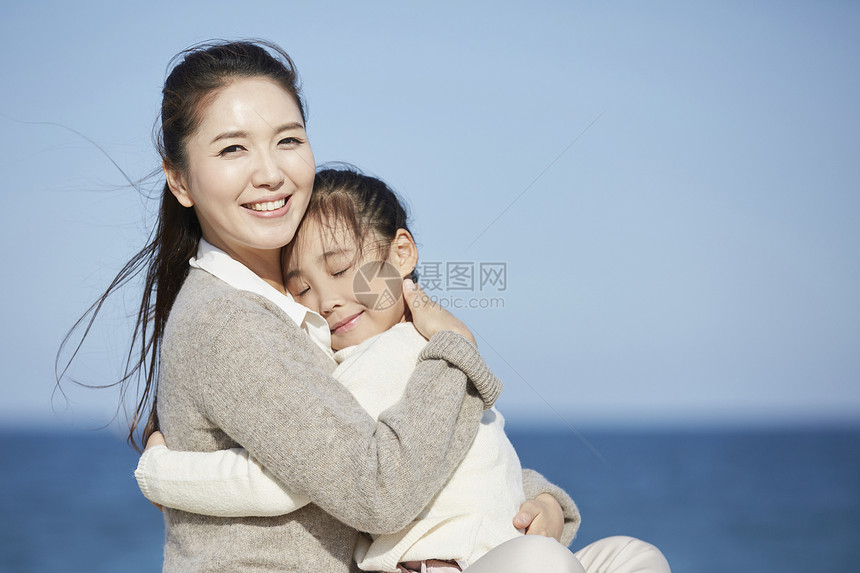 熊抱坐轮廓母亲女儿旅行海洋图片