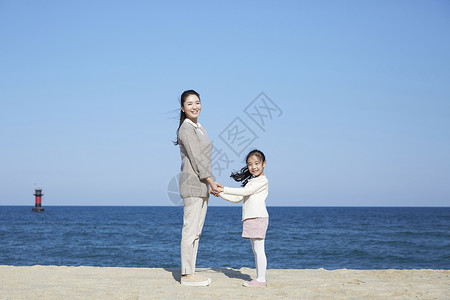海边的母女牵手旅行图片