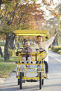 母女骑行双人自行车游览公园图片