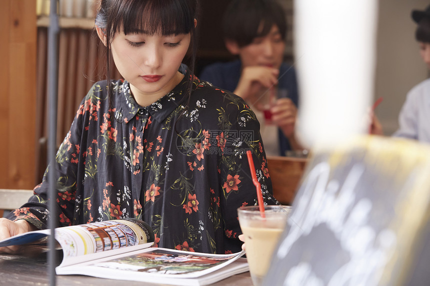 女孩在咖啡店看杂志图片
