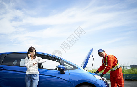 女子呼叫道路车辆救援服务人员检测修车图片