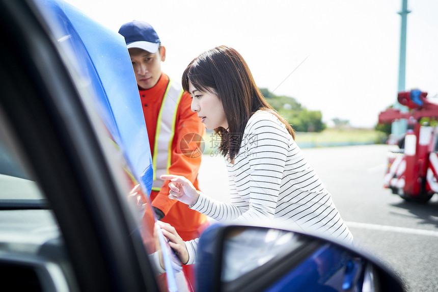 女司机为道路救援服务人员讲解故障问题图片