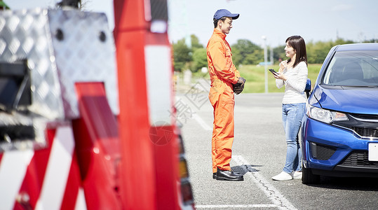 道路救援服务人员为女司机讲解维修建议图片