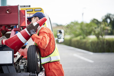 搬运桶锥放置路障的道路救援服务人员图片