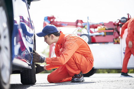 道路救援服务人员拆卸更换轮胎图片