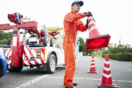 搬运放置路障锥桶的道路救援服务人员图片