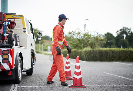 锥形交通路标放置路障锥桶的道路救援服务人员背景