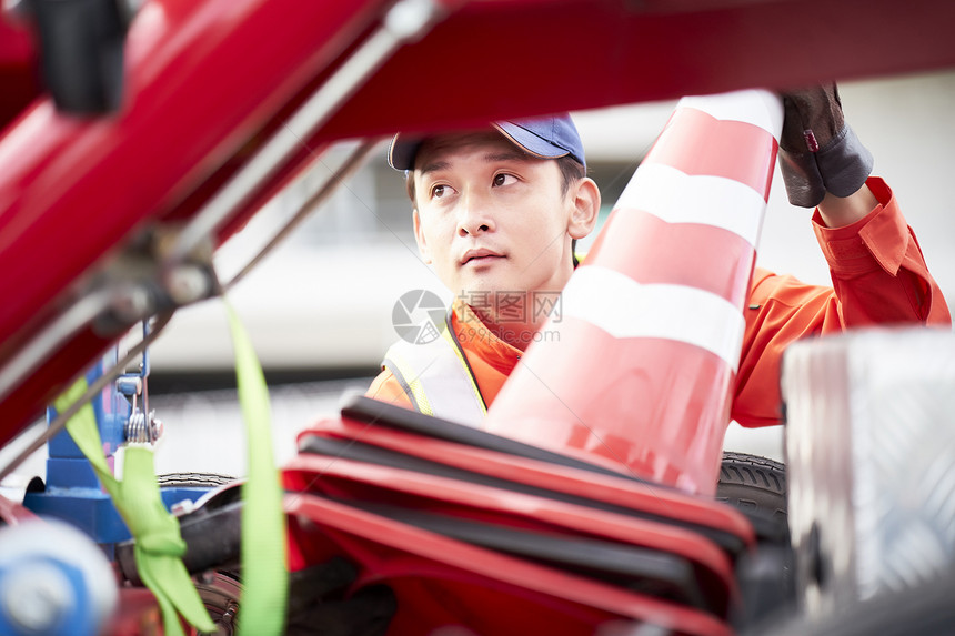 搬运路障锥桶的道路救援服务人员图片