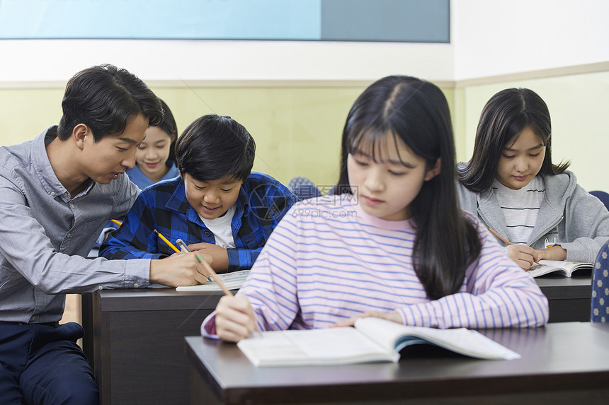 老师在教室里指导学生写作业图片