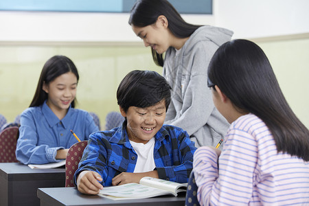 老师在教室里指导学生写作业图片