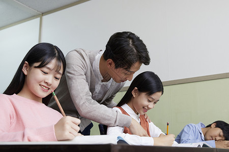 老师在教室里指导学生写作业图片