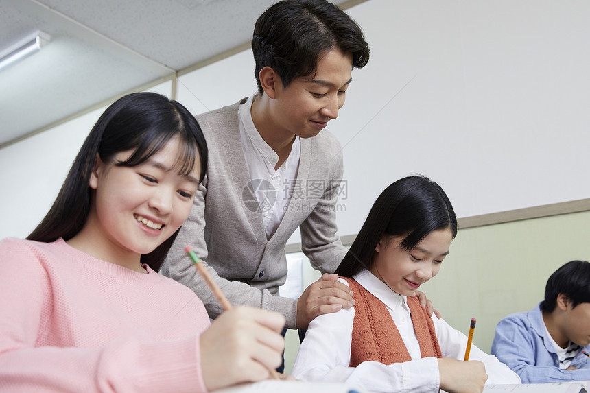 老师在教室里指导学生写作业图片