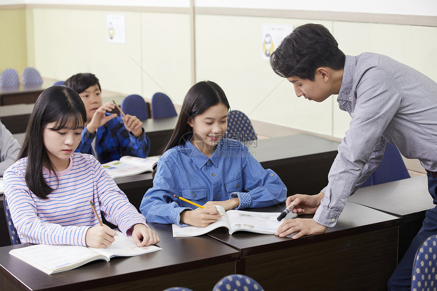 老师在教室里指导学生写作业图片