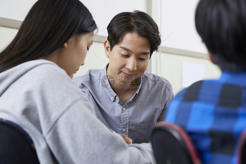 老师在教室里指导学生写作业图片