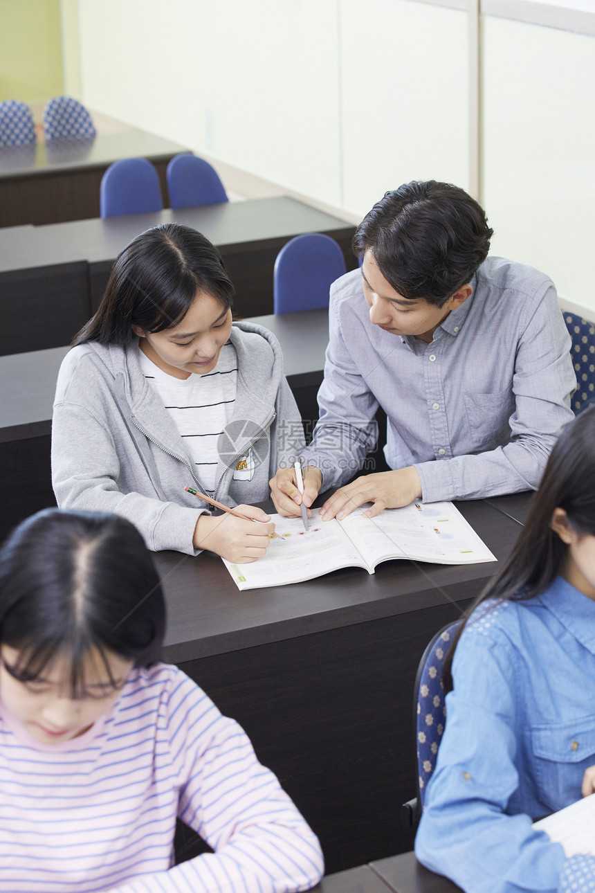 老师在教室里指导学生写作业图片