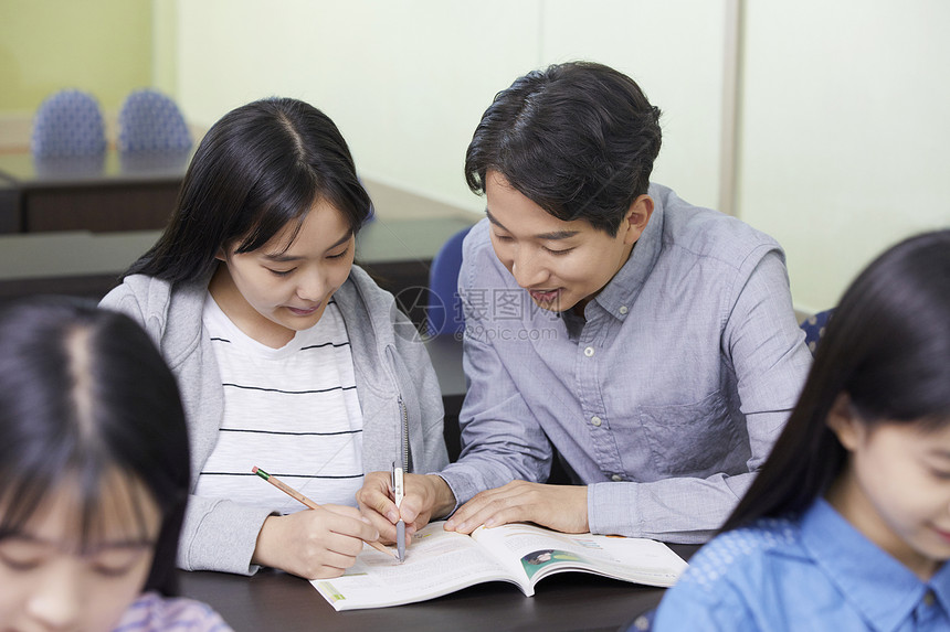 老师在教室里指导学生写作业图片