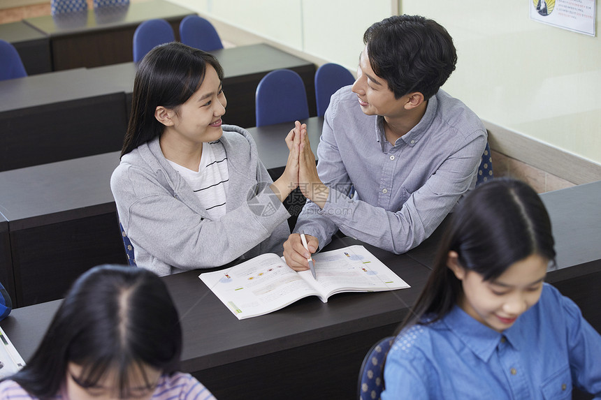 老师在教室里指导学生写作业图片