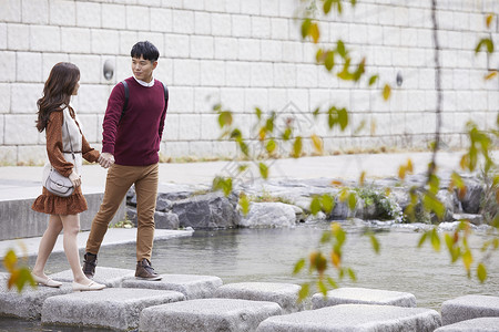 户外的浪漫的韩国情人情侣约会溪流踏脚石图片
