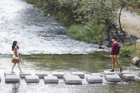 韩国人年轻女子岩石情人情侣约会溪流踏脚石图片