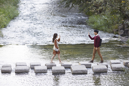 举手大学生岩石情人情侣约会溪流踏脚石图片