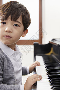 男孩在弹钢琴背景图片