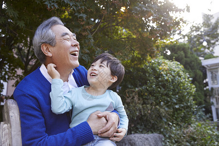 祖父开心拥着孙子坐在椅子上图片