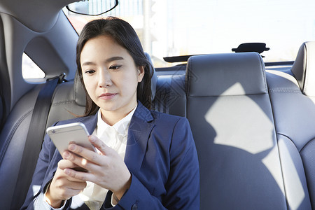 坐在车上使用手机的职业女性图片