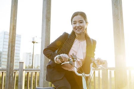 户外骑着自行车出行的青年女子图片