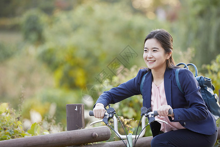 背着背包骑车的年轻女子图片