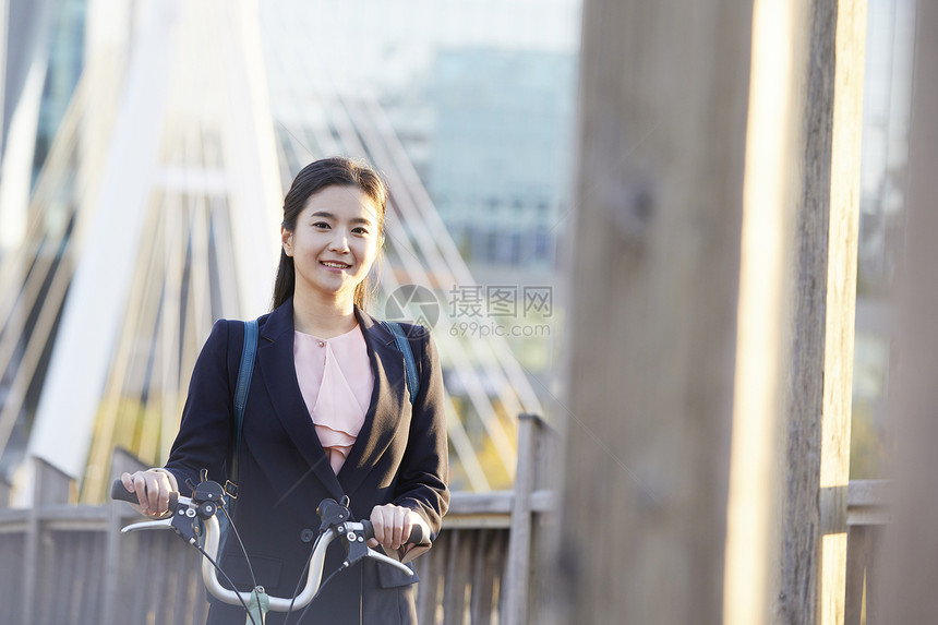 微笑着推着自行车的女青年图片