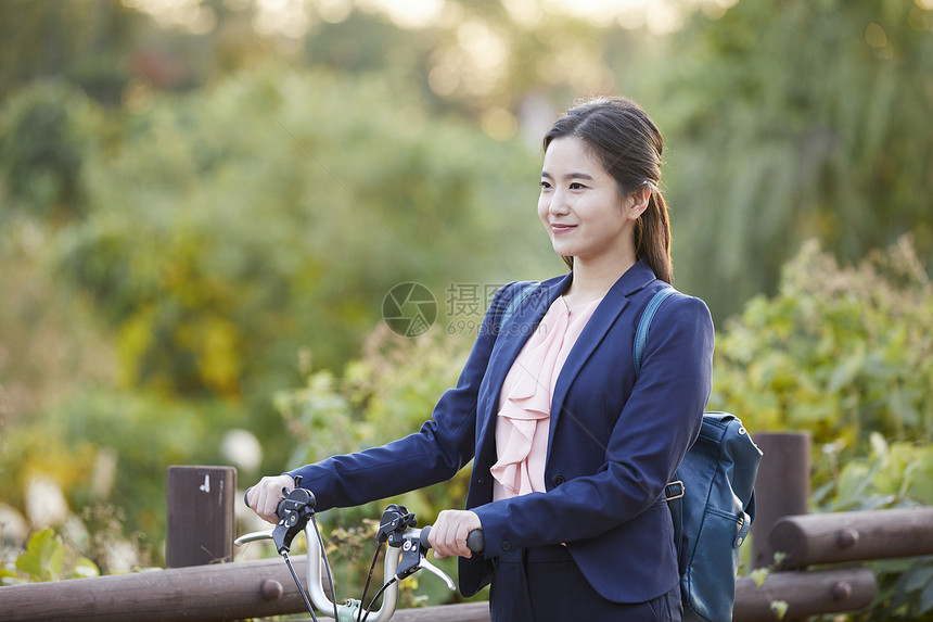 推着自行车微笑的年轻女性图片